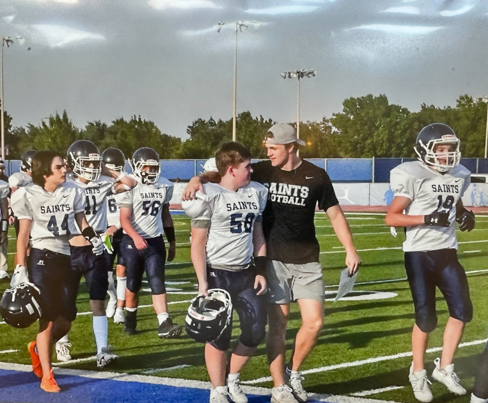 <strong>Wes Smith walks off the field with his arm around a middle school player at All Saints' Episcopal School in Fort Worth, where he helped out as a coach.&nbsp;&ldquo;I think you can say that sums up Wes, right there,&rdquo; his mother Dorree said.</strong>&nbsp;(Courtesy All Saints&rsquo; Episcopal School)