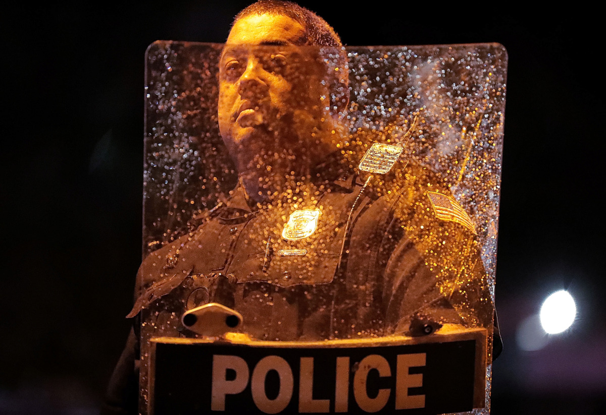 <strong>Rain and scratches cloud up an officer's riot shield after protesters took to the streets of Frayser in anger over the shooting a youth by U.S. Marshals earlier Wednesday.&nbsp;</strong><span class="s1"><b>Dozens of protesters clashed with police, throwing stones and tree limbs until police forces broke up the angry crowd with tear gas.</b> (Jim Weber/Daily Memphian)</span>