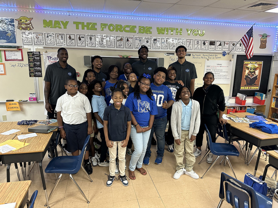 <strong>David Jones, Joe Cooper, Malcolm Dandridge and Nick Jourdain (back left to right) pose with Bruce Elementary School students (front) Sept. 22 at a Coaching for Literacy event.</strong> (Parth Upadhyaya/The Daily Memphian)