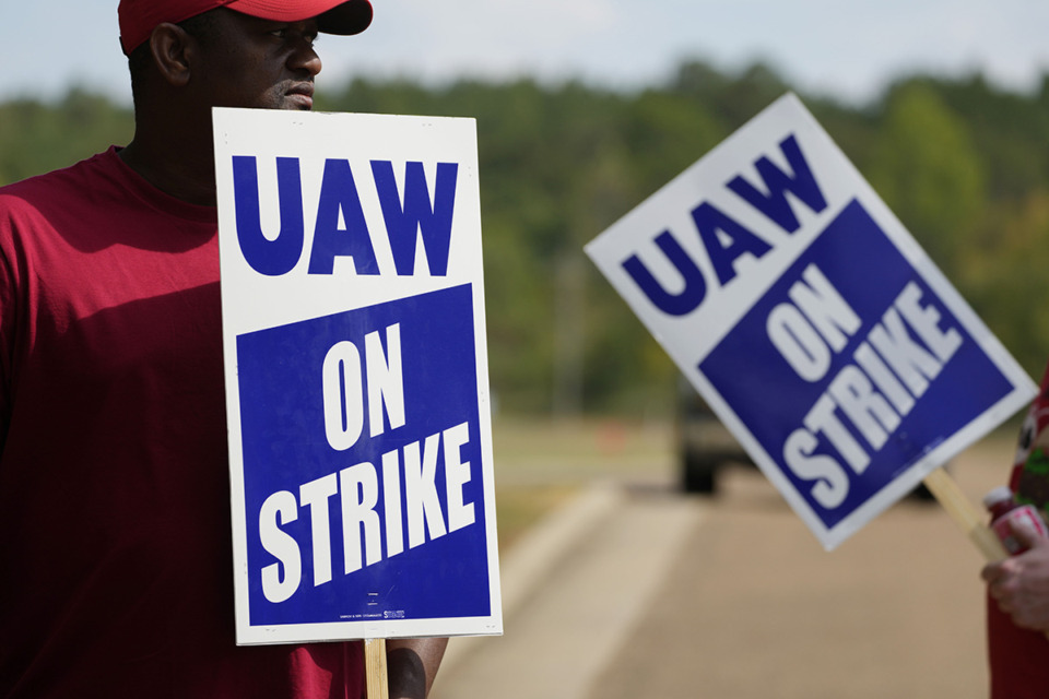 <strong>United Auto Workers members hold picket signs outside the General Motors Customer Care and After-Sales facility in Brandon, Miss., Sept. 22. Unionized workers joined others in new nationwide walkouts as the labor standoff continues.</strong> (Rogelio V. Solis/AP Photo)