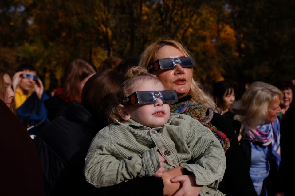 <strong>People look at the sun through special glasses during a partial solar eclipse in Warsaw, Poland, Oct. 25, 2022.</strong> (Michal Dyjuk/AP file)