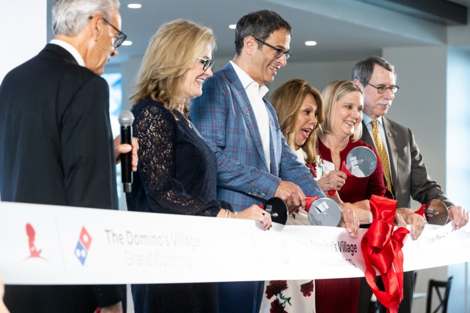 <strong>Russell Weiner, CEO of Domino&rsquo;s, uses a pizza cutter to slice the ribbon to open The Domino&rsquo;s Village at St. Jude. The village features 140 housing units that range from one- to three-bedroom spaces for patients who travel more than 35 miles to undergo treatment that requires an overnight stay.</strong> (Brad Vest/Special to The Daily Memphian)