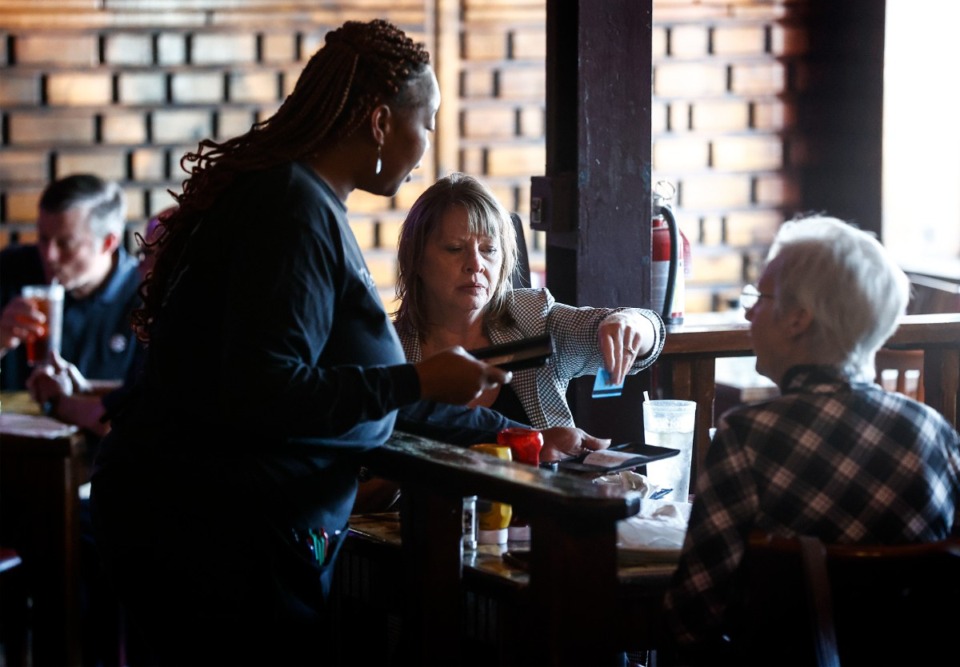 <strong>Blue Monkey Downtown customers pay for their meal Oct. 9. Blue Monkey is one of several area restaurants that are adding auto gratuity to customer bills.</strong> (Mark Weber/The Daily Memphian)