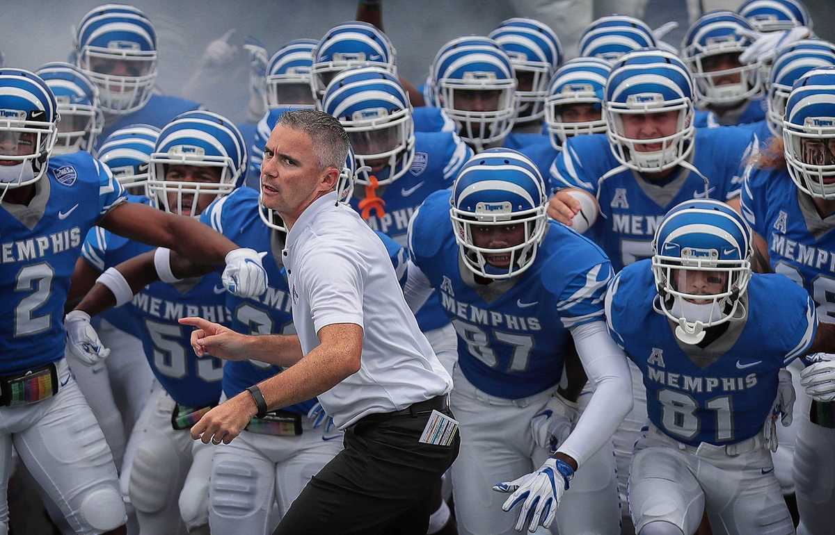 <strong>University of Memphis coach Mike Norvell (center) leads his team onto the field against UCF at the Liberty Bowl Memorial Stadium on Oct. 13, 2018.</strong> (Jim Weber/Daily Memphian)