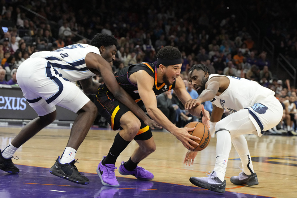 <strong>The Memphis Grizzlies signed guard Jaylen Nowell to a second 10-day contract. Nowell, right, fights for the loose ball with Memphis Grizzlies guard Vince Williams Jr. (5) against Phoenix Suns guard Devin Booker (1) during the game, Saturday, Dec. 2, 2023, in Phoenix. Phoenix won 116-109.</strong> (Rick Scuteri/AP Photo)