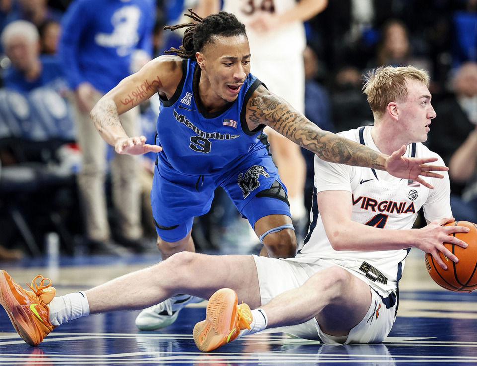 <strong>Memphis Tigers defender Caleb Mills (left) battles Virginia guard Andrew Rohde (right) for a loose ball during action Dec. 19.</strong> (Mark Weber/The Daily Memphian)