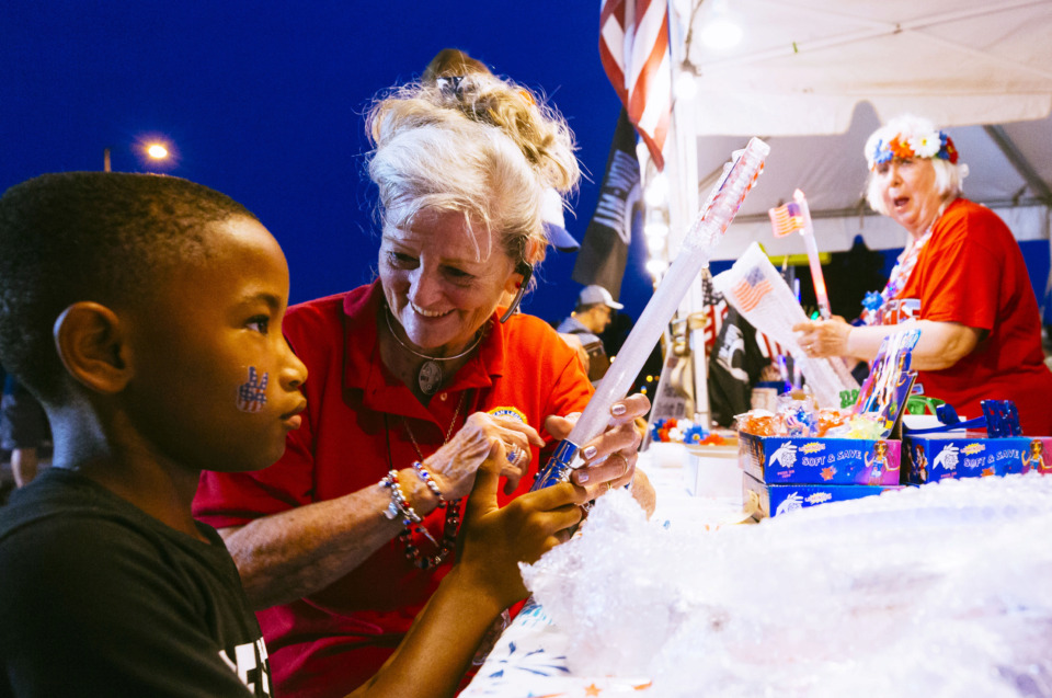 <strong>American Legion Auxillary member Glenda Vilseck shows Jeremiah Moore how to use electronic sparkler at Bartlett&rsquo;s annual Star Spangled Fireworks Extravaganza on July 3, 2019, at the Bobby K. Flaherty Municipal Center. Bartlett was one of several suburban cities to celebrate Independence Day with fireworks shows Wednesday.&nbsp;</strong>(Ziggy Mack/Special to The Daily Memphian)