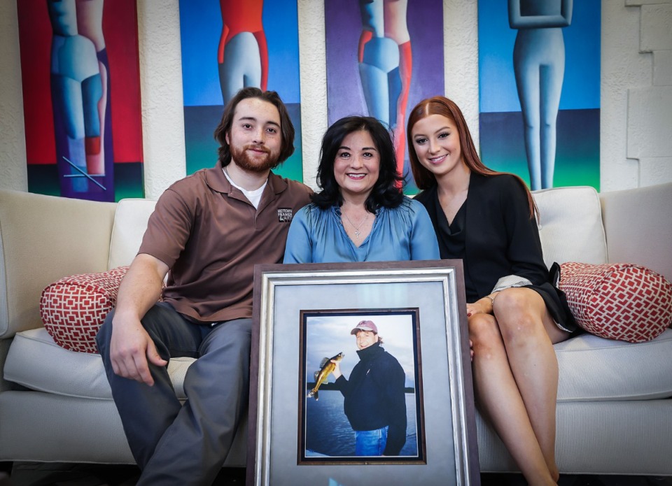 <strong>Joseph Bubnick, Carol Bubnick and Anna Bubnick pose for a portrait with a photo of their late husband and father, Danny Bubnick, at Midtown Framer and Art Dec. 22, 2023.</strong> (Patrick Lantrip/The Daily Memphian)