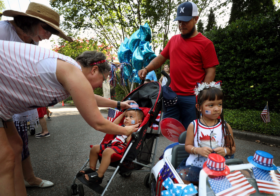 <strong>Shantih Smythe helps young Jayden Palacios get his hat on just before the beginning of Central Gardens' Independence Day parade on Thursday. July 4, 2019.</strong> (Patrick Lantrip/Daily Memphian)