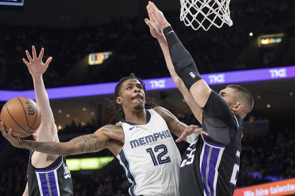 <strong>Memphis Grizzlies guard Ja Morant (12) elevates to shoot defended by Sacramento Kings center Alex Len and Sacramento Kings guard Kevin Huerter, left, in the New Year&rsquo;s Eve 2023 game.</strong> (Nikki Boertman/AP Photo)