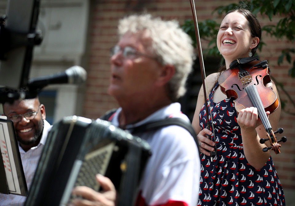 <strong>Myra Patterson (right) and Joseph Miller (left) from the Museworthies react as fellow band member Jim Bement does a riff on the song "Grand Old Flag" after the annual Fourth of July parade in the Cooper Young neighborhood on July 4, 2019.</strong> (Jim Weber/Daily Memphian)