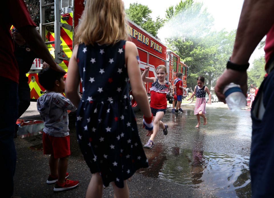 <strong>Isabella Getschman leaps over a puddle at the corner of Willett Street and Carr Avenue after splashing around underneath the fire engine-turned-splashpad Thursday, July 4, 2019.</strong> (Patrick Lantrip/Daily Memphian)