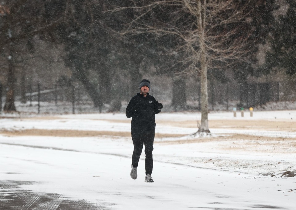 <strong>Russell Jackson trots through Overton Park, on a 10-mile run as snow falls on Sunday, Jan. 14, 2024.</strong> (Mark Weber/The Daily Memphian)