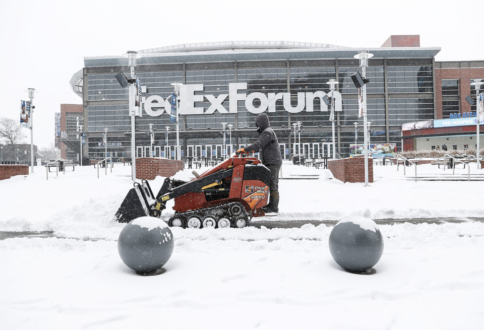 <strong>Workers clear sidewalks outside FedExForum as snow falls Jan. 15.</strong> (Mark Weber/The Daily Memphian)