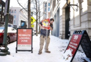 <strong>Anthony Wiggins pours salt on snow covered sidewalks Downtown on Wednesday, January 17, 2024.</strong> (Mark Weber/The Daily Memphian)