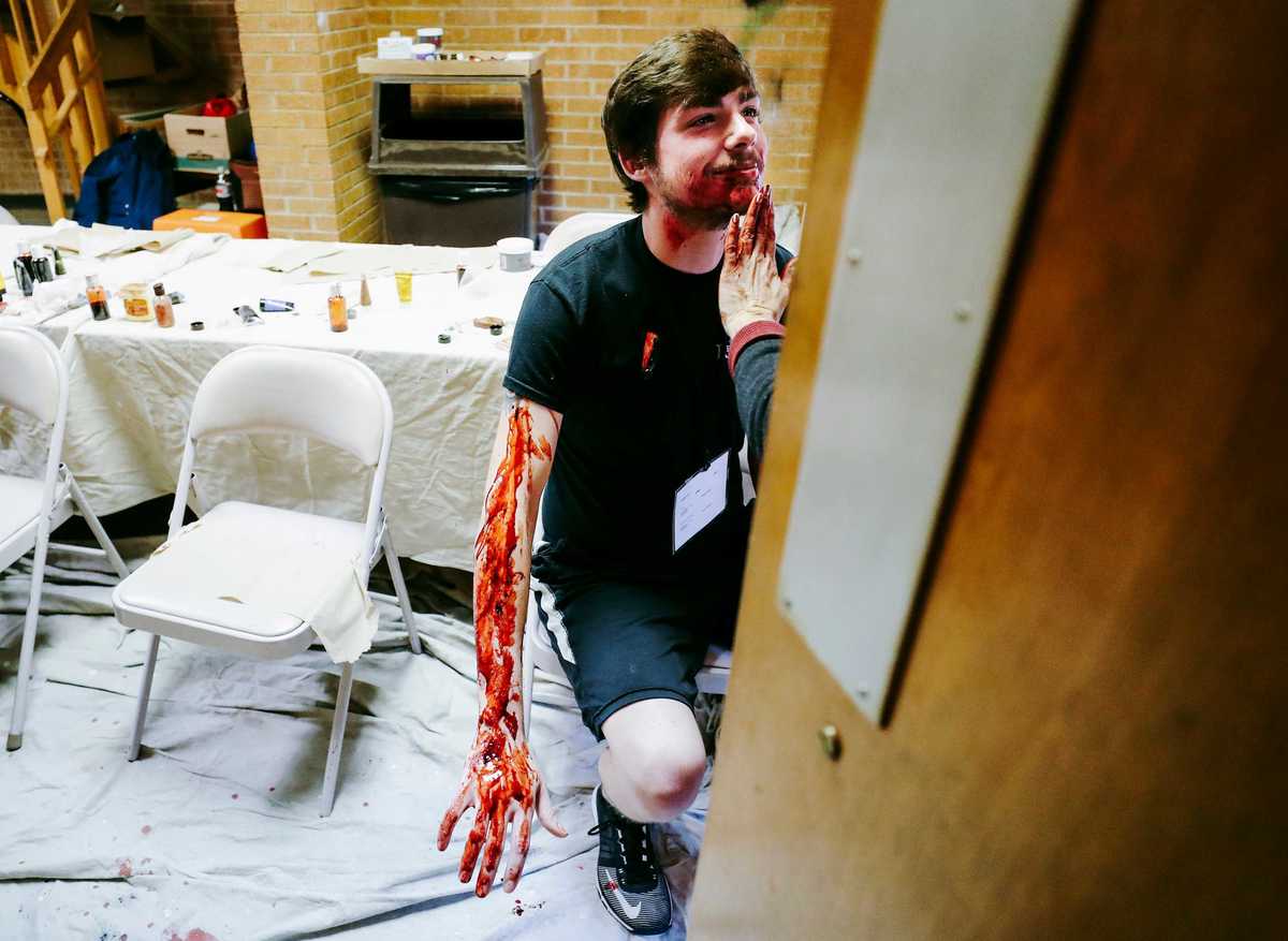 <strong>Donna Dobro applies fake blood and other makeup on Dylan Price, 21, before an airport disaster drill at Memphis International Airport on Monday, Oct. 15.&nbsp;<span style="color: black;">The Federal Aviation Administration requires a full-scale disaster exercise every three years. After a 2016 drill, Memphis airport officials decided to have it every two years to sharpen emergency-response procedures.</span></strong>&nbsp;(Houston Cofield/Daily Memphian)