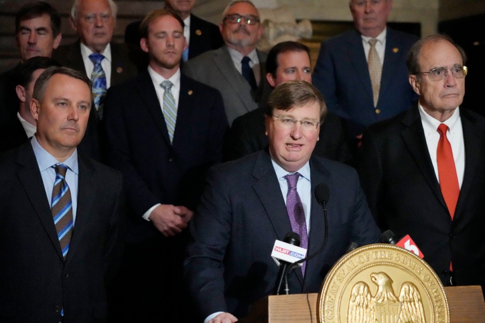<strong>Mississippi Republican Gov. Tate Reeves, middle, stands with House Speaker Jason White, R-West, left, and Republican Lt. Gov. Delbert Hosemann, right, as well as the legislators behind him, as he praises the passing of a state incentives package for Marshall County.</strong> (Rogelio V. Solis/AP)