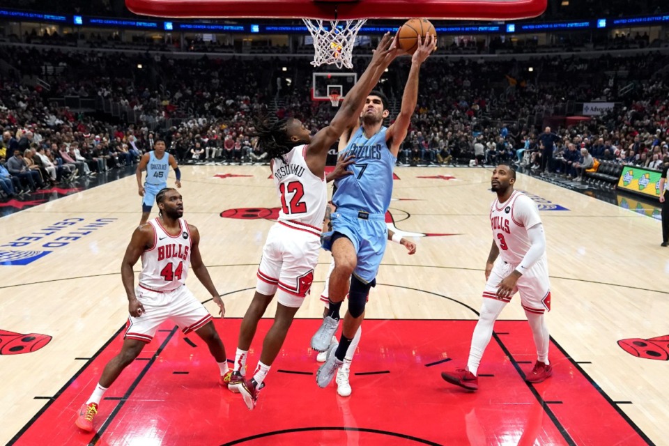 <strong>Memphis Grizzlies' Santi Aldama (7) drives to the basket as Chicago Bulls' Ayo Dosunmu defends during the first half of an NBA basketball game Saturday, Jan. 20, 2024, in Chicago.</strong> (AP Photo/Charles Rex Arbogast)