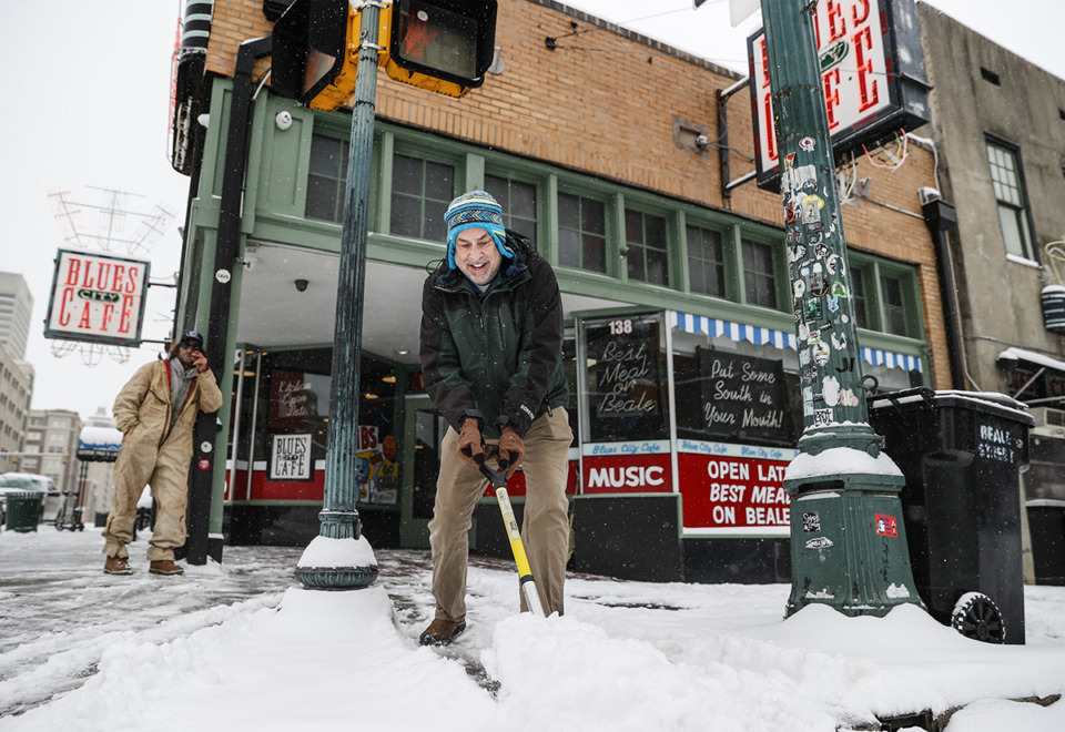 <strong>A combination of voluntary energy conservation and somewhat recent infrastructure improvements allowed the city to weather the storm with minimal power outages. Ken Whitehead clears the sidewalk outside Blues City Cafe as snow falls on Monday, January 15, 2024.</strong> (Mark Weber/The Daily Memphian)