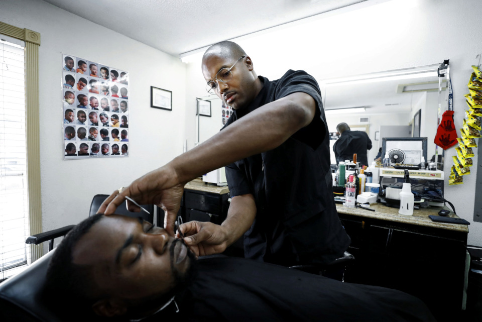 <strong>Barber Carnell Vann Jr. touches up customer Jessie Marshall Jr.&rsquo;s edges while giving him a haircut Tuesday, July 9, 2019. Vann recently received a $20,000 Inner City Economic Development loan to open his own barbershop in the Frayser area.</strong> (Mark Weber/Daily Memphian).