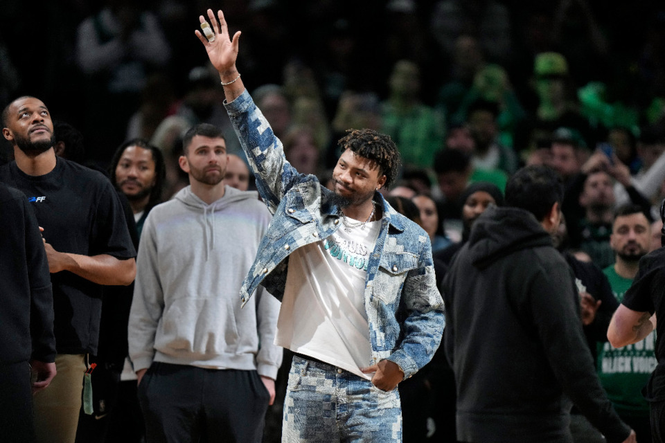 <strong>Memphis Grizzlies guard Marcus Smart, center, waves to the crowd as he is honored with the Boston Celtics' Heroes Among Us award in the first half of an NBA basketball game between the Celtics and the Grizzlies, Sunday, Feb. 4, 2024, in Boston. The former Celtics player was honored with the award for his dedication to helping others.</strong> (AP Photo/Steven Senne)