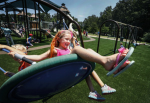 <strong>Brooke Winburn, 6, swings at the newly rebuilt Playground of Dreams in Arlington, during a grand-opening event Friday, July 12, at Hughes-College Hill Park. The old playground was torn down in March after becoming dilapidated and being declared unsafe.&nbsp;</strong>(Mark Weber/Daily Memphian)