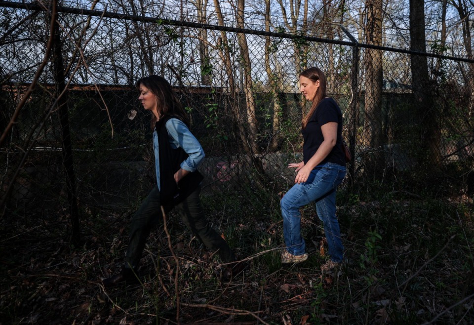 <strong>Annelise Danielson (left) and Melissa McMasters hug a fence line near Lick Creek that will that will eventually become a new trail in Overton Park's Old Forest.</strong> (Patrick Lantrip/The Daily Memphian)