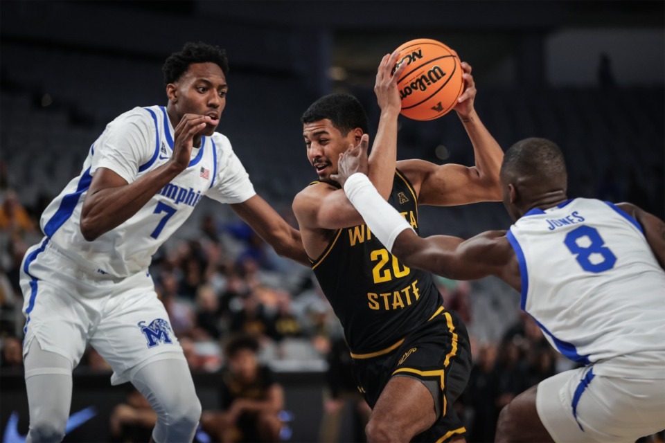 <strong>Wichita State guard Harlond Beverly (20) drives the lane against University of Memphis forwards David Jones (8) and Nae'Qwan Tomlin (7) during the March 14, 2024, AAC Tournament game in Fort Worth, Texas.</strong> (Patrick Lantrip/The Daily Memphian)