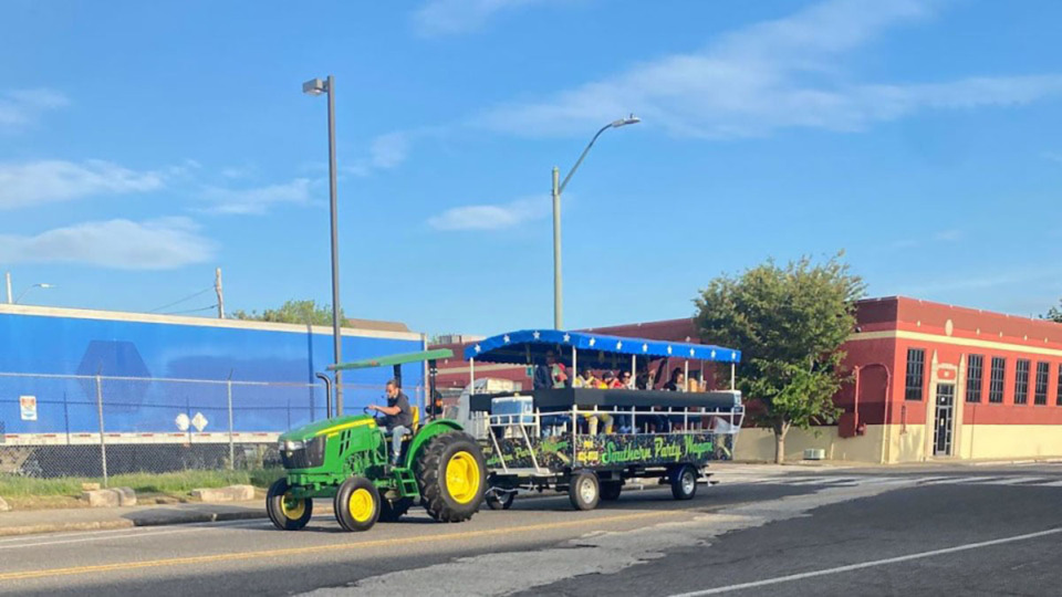 <strong>The Southern Party Wagon carries guests in a covered trailer pulled by a John Deere tractor through Downtown Memphis April 22, 2023. An ordinance for&nbsp;&ldquo;entertainment vehicles&rdquo; regulations will face a third and final vote at a Tuesday, March 19, Memphis City Council meeting.</strong> (Jane Donahoe/The Daily Memphian file)