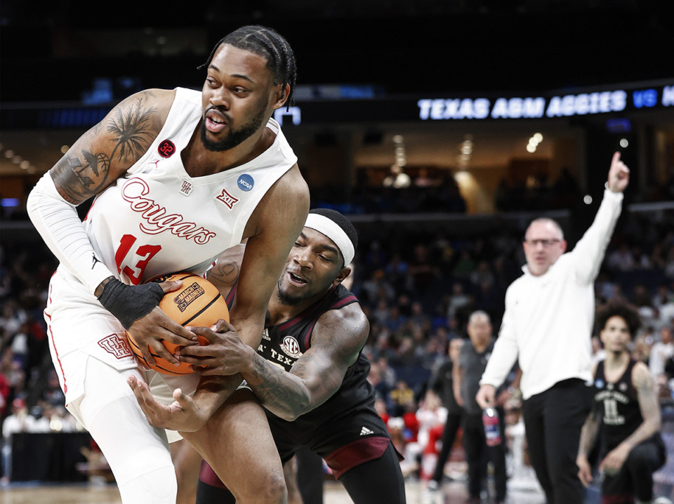 <strong>Houston center J'Wan Roberts (left) hangs onto a loose ball in front of Texas A&amp;M defender Tyrece Radford (right) during action in the NCAA Tournament on Sunday, March 24, 2024.</strong> (Mark Weber/The Daily Memphian)
