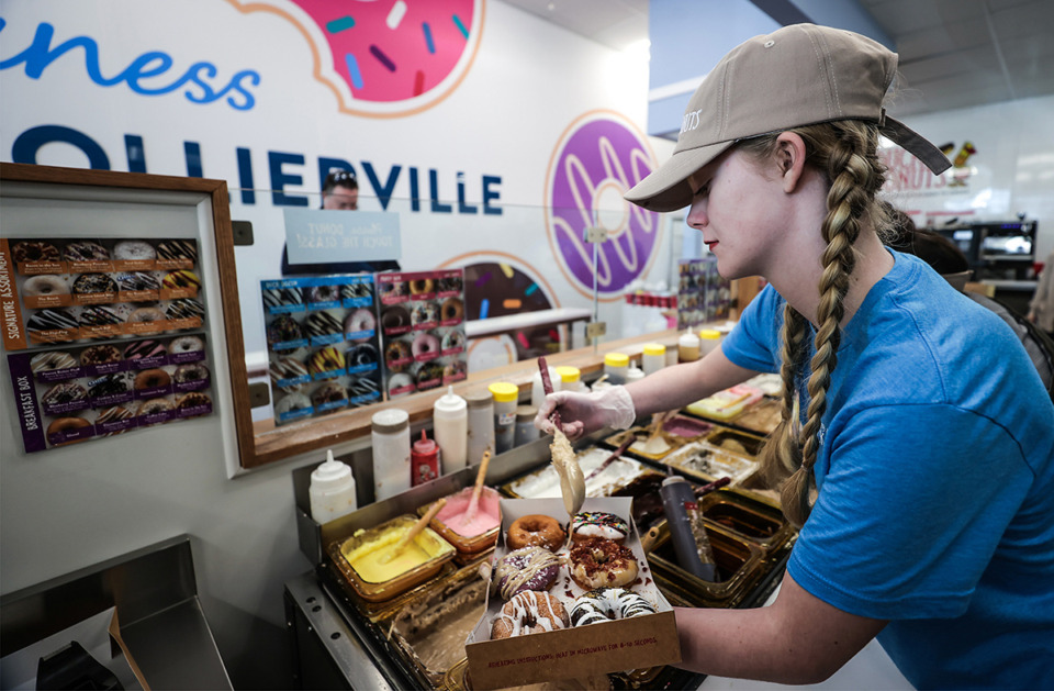 <strong>Madison Arndt puts the finishing touches on a fresh batch of donuts at Duck Donuts&rsquo; new location in Collierville March 29.</strong> (Patrick Lantrip/The Daily Memphian)