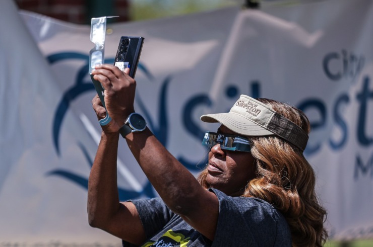 <strong>Sikeston, Missouri, city clerk Rhonda Council tries to take an improvised eclipse photo with her cell phone in on April 8, 2024.</strong> (Patrick Lantrip/The Daily Memphian)