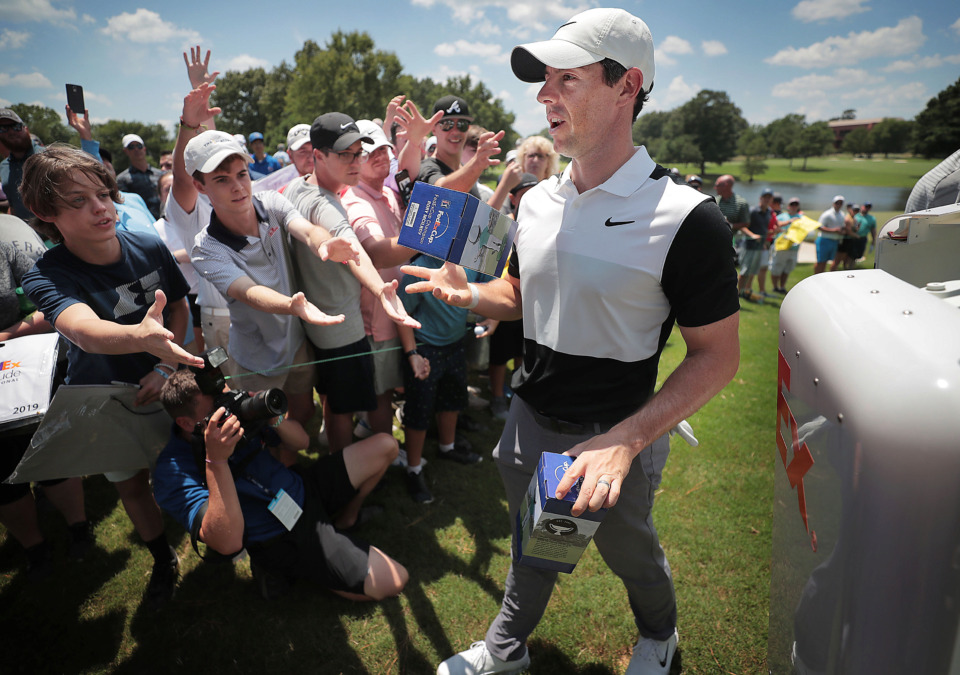 <strong>Rory McIlroy passes out bobbleheads disgorged from a robot on the 9th green during a day of practice rounds at the WGC - FedEx St. Jude Invitational at TPC Southwind on Wednesday, July 24, 2019.</strong> (Jim Weber/Daily Memphian)
