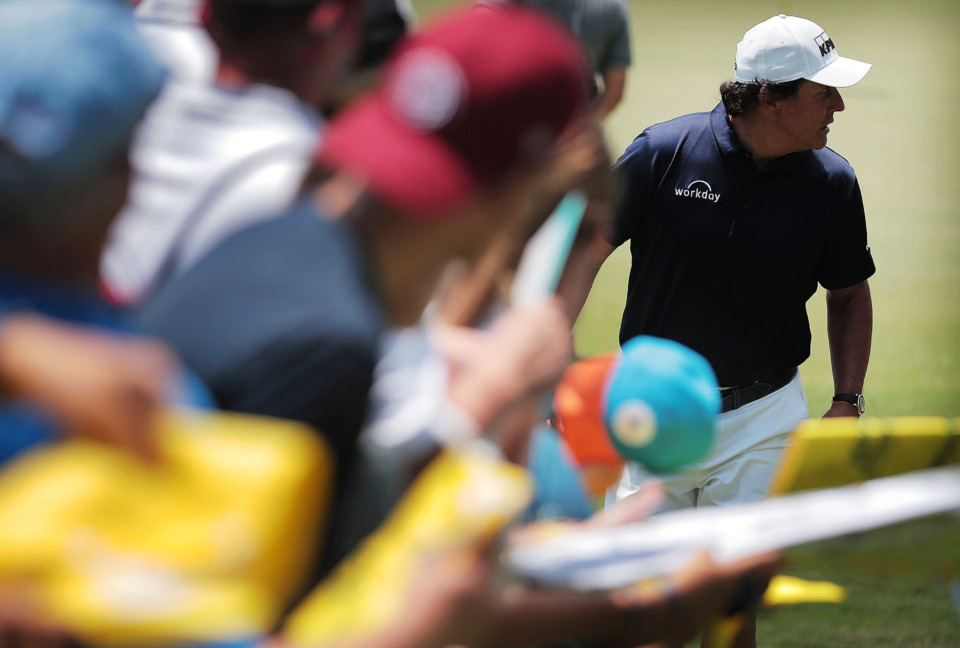 <strong>Phil Mickelson (right) signs autographs on the 9th green during a day of practice rounds at the WGC - FedEx St. Jude Invitational at TPC Southwind on Wednesday, July 24, 2019.</strong> (Jim Weber/Daily Memphian)