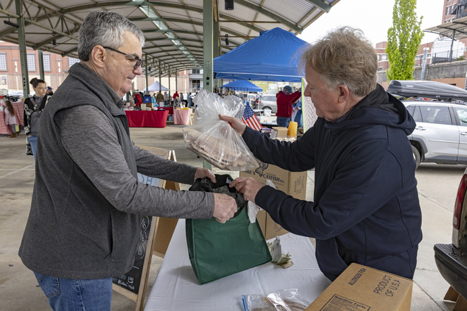 <strong>Mississippi catfish farmer Earl Lake sells frozen catfish to longtime patron Andrew Landrum at the Memphis Farmers Market Downtown April 6.</strong> (Ziggy Mack/Special to The Daily Memphian)