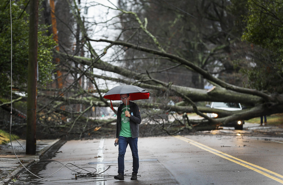 <strong>The Mid-South is expecting showers and thunderstorms Wednesday. Mark Parrish surveys the damage of a fallen tree on McLean after high winds and heavy rains that hit the area in the early morning hours of Saturday, Jan. 11, 2020.</strong> (Mark Weber/The Daily Memphian file)