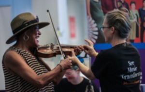 <strong>Rebecca Arendt (right) shows Irine Onciano how to play the violin at Art for All at the Memphis Brooks Museum May 11, 2024.</strong> (Patrick Lantrip/The Daily Memphian)