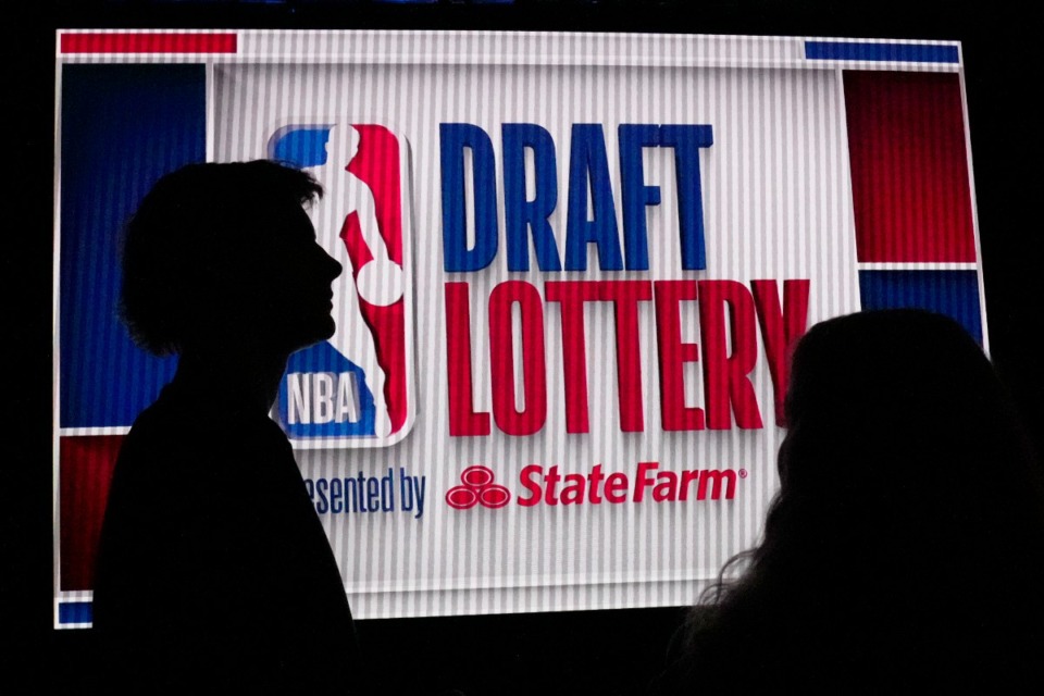 <strong>NBA basketball draft prospect Johnny Furphy, left, looks at the draft lottery order in front of a draft lottery sign before the draft lottery in Chicago, Sunday, May 12, 2024.</strong> (Nam Y. Huh/AP Photo)