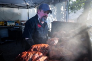 <strong>Head grill master Tommy Shive, with The Usual Saucepects, checks on his pork butts during the opening day of the World Championship Barbecue Cooking Contest at Liberty Park May 15, 2024.</strong> (Patrick Lantrip/The Daily Memphian)