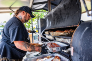 <strong>Mel Chmilar pulls ribs off of the grill Thursday, May 16, 2024, during Memphis in May.</strong> (Benjamin Naylor/The Daily Memphian)