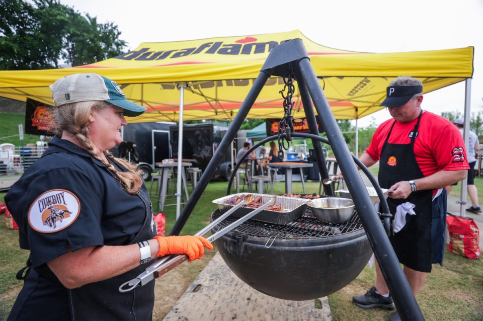 <strong>Christie Vanover and Tim McIntosh with B&amp;B Charcoal work the cowboy cauldron during the opening day of SmokeSlam at Tom Lee Park May 16, 2024.</strong> (Patrick Lantrip/The Daily Memphian)