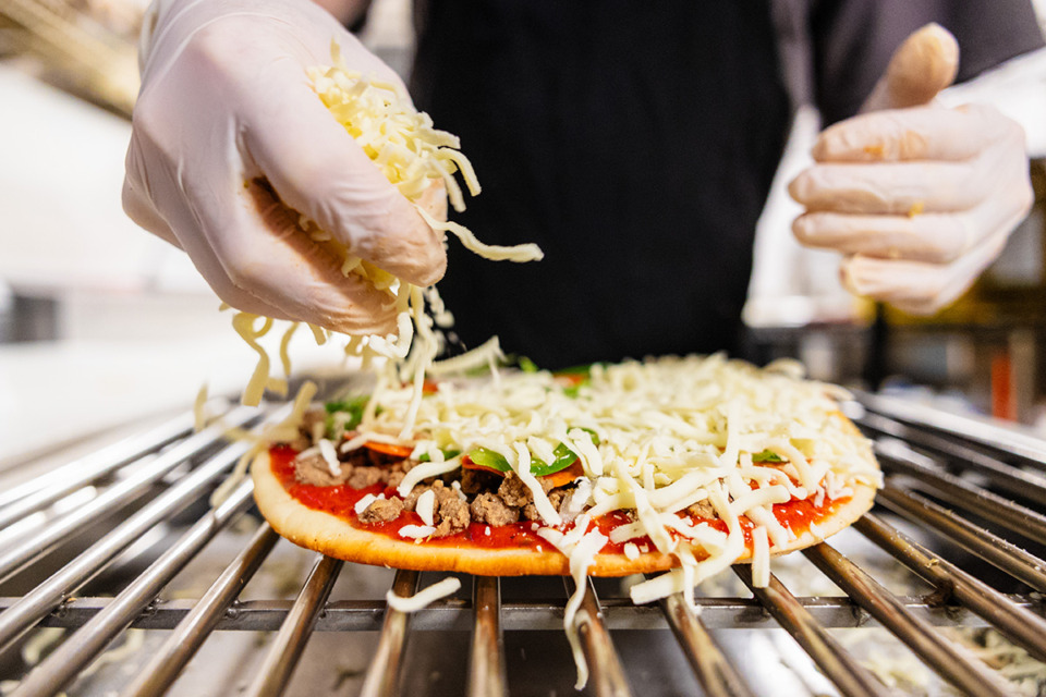 <strong>Fox Ridge Pizza&rsquo;s Cody Burdison places cheese on top of the Fox Ridge Special pizza.</strong> (Benjamin Naylor/The Daily Memphian)