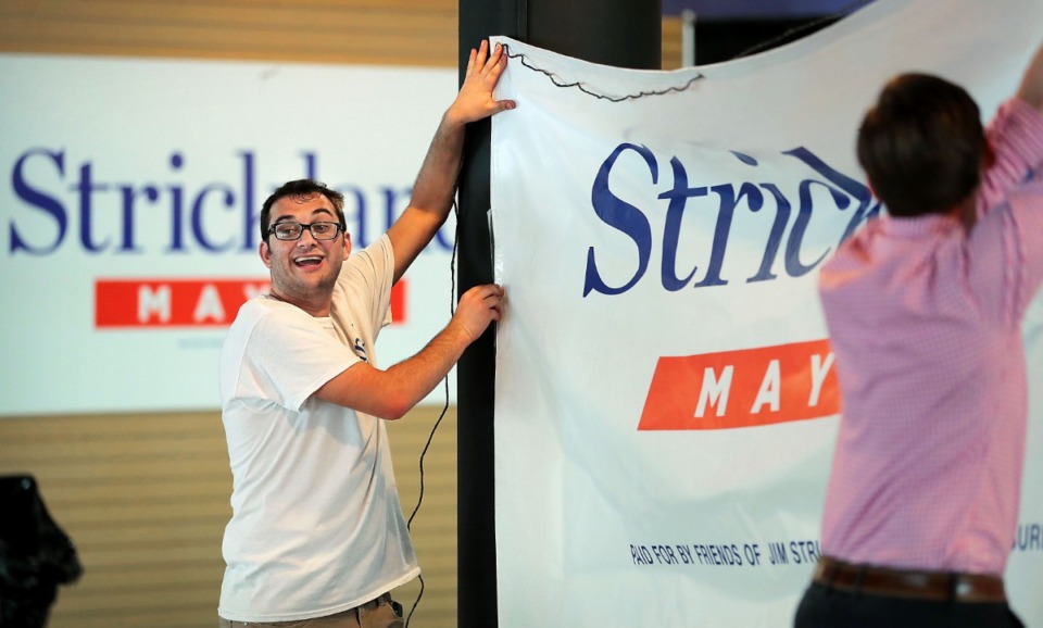 <strong>Daniel Saharovich (left) and volunteer Cole Perry help set up Memphis Mayor Jim Strickland's campaign headquarters on July 30, 2019, in the Poplar Plaza shopping center. Strickland said his goal is to "accelerate momentum" if elected to a second four-year term.</strong>&nbsp;(Jim Weber/Daily Memphian)