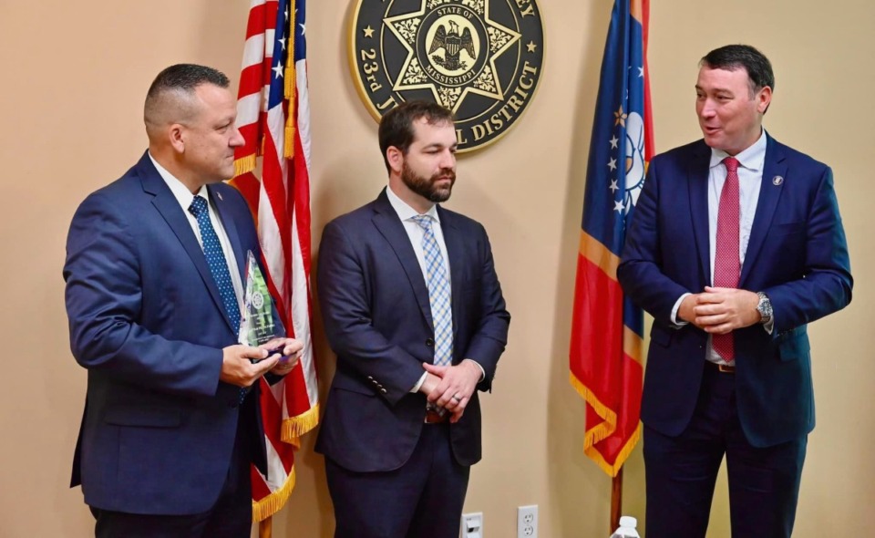 <strong>Mississippi Bureau of Investigation&rsquo;s Special Agent Heath Farish, left, holds an award from DeSoto County District Attorney Matthew Barton, center, with Mississippi Public Safety Commissioner Sean Tindell, right.</strong> (Courtesy Mississippi Department of Public Safety)
