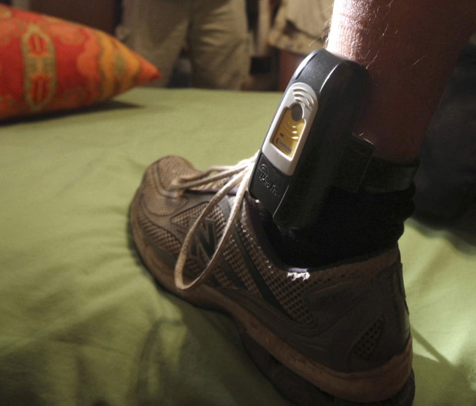 <strong>Shelby County has intermittently funded GPS monitors in the past but soon Shelby County judges may be required to order some defendants to wear the monitors. In this Aug. 3, 2009, file photo, Parole Agent Steve Nakamura uses a flashlight to inspect a GPS tracker worn on the ankle of a parolee in Rio Linda, Calif.</strong> (Rich Pedroncelli/AP Photo file)