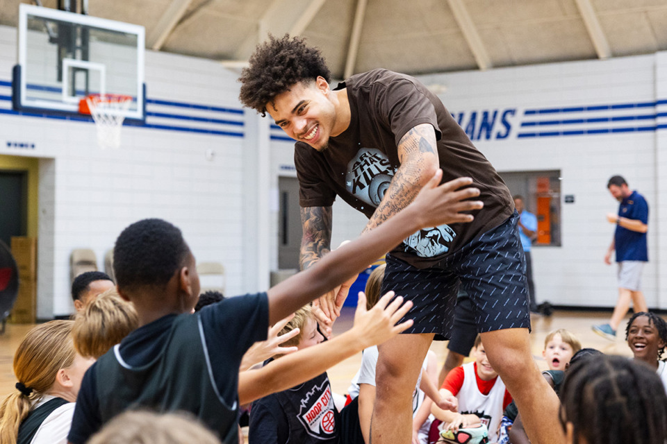 <strong>Former Memphis Tiger and current Golden State Warrior Lester Quinones gives out high-fives while visiting the players of Hoop City Basketball Club at Christ Church Memphis June 6, 2024.</strong> (Benjamin Naylor/The Daily Memphian)