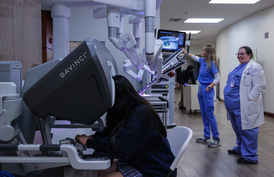 <strong>St. Mary's sophomore Stephanie Chen tries her hand at the Da Vinci Xi while Hannah Huff and Dr. Moriah Wright look on at Saint Francis Hospital in East Memphis April 9, 2024.</strong> (Patrick Lantrip/The Daily Memphian)