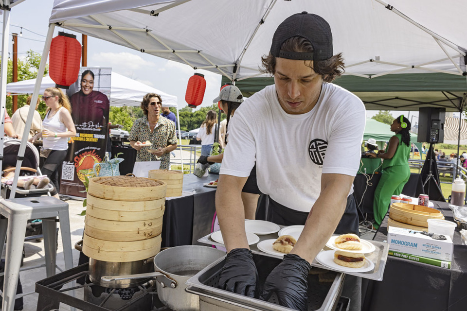 <strong>Chef Arturo Leighton of Good Fortune Co. prepare and serve Bluff City Bao (handmade gum bao, five-spice dry rub pork, and house pickles) at their food booth during Project Green Fork&rsquo;s Loving Local event at Grind City Brewery in Uptown on Sunday, June 9, 2024.</strong> (Ziggy Mack/Special to The Daily Memphian)