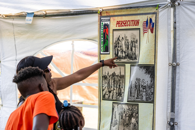 <strong>A mother shows her kids a photo depicting persecution inside the Juneteenth outside museum June 15.</strong> (Benjamin Naylor/The Daily Memphian)