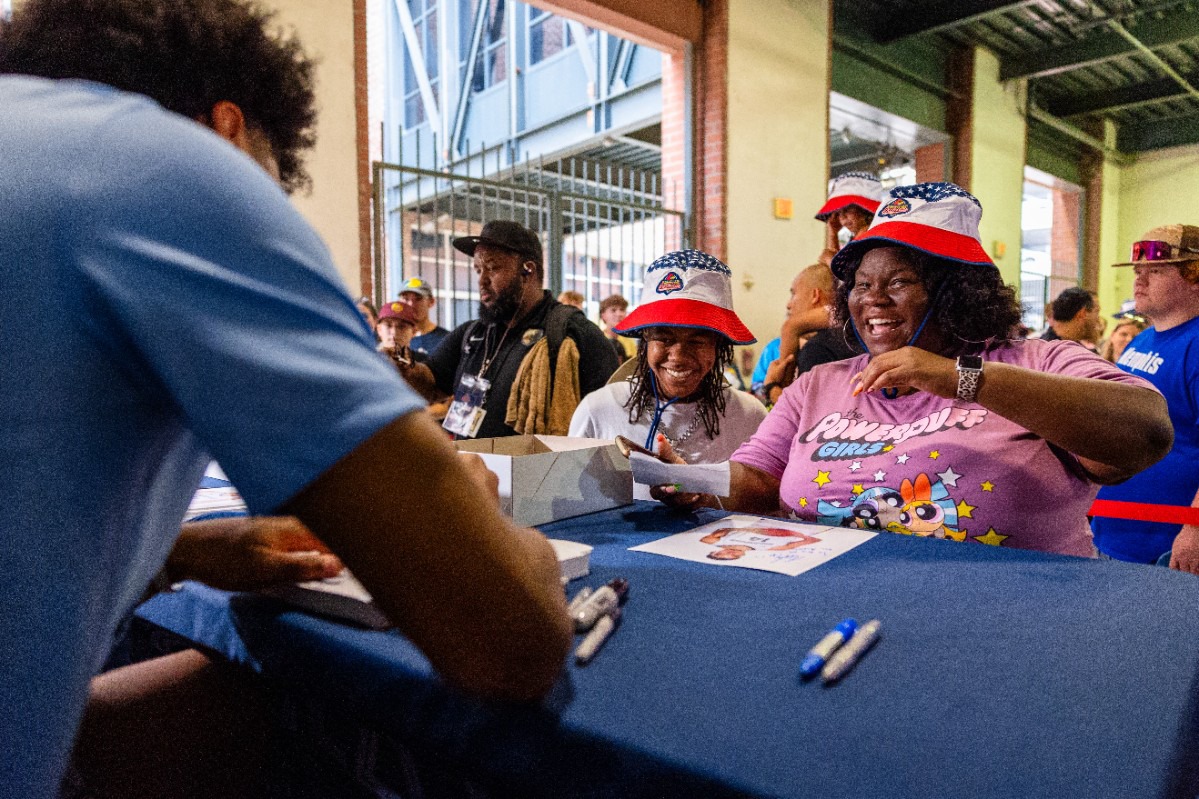 <strong>Fans get a kick as Jaylen Wells, a Memphis Grizzlies 2024 NBA Draft pick, signs a picture for them at the Memphis Redbirds annual Red, White and Boom celebration game July 3, 2024.</strong> (Benjamin Naylor/The Daily Memphian)